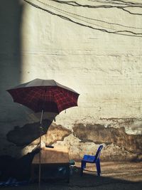 Empty chair on shore against wall
