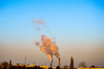 Smoke emitting from chimney against clear blue sky