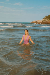 Rear view of woman swimming in sea