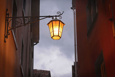 Low angle view of illuminated street light against building