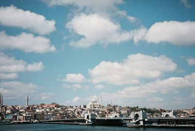 Buildings by sea against sky