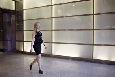 Full length of woman standing against wall