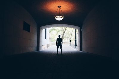 Silhouette man standing in tunnel