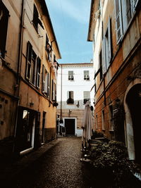 Low angle view of narrow alley amidst buildings in city