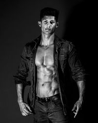 Portrait of young man against black background