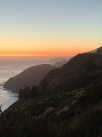 Scenic view of sea and mountains against sky during sunset