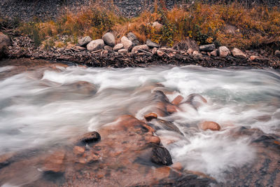 View of stream flowing through rocks