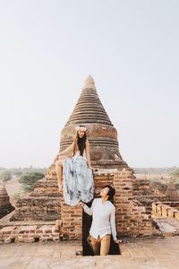 Couple at old ruins against clear sky
