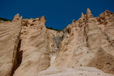 Low angle view of rock formations against sky