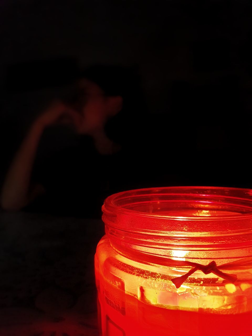 CLOSE-UP OF LIT CANDLE IN JAR