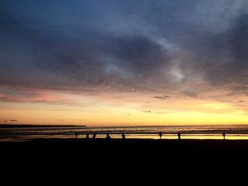 Scenic view of beach against sky at sunset