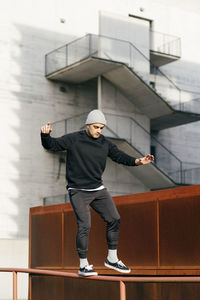 Athletic man doing parkour balance exercises outdoors in urban scene person