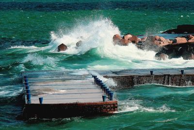 Waves splashing on sea against sky