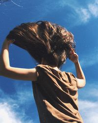 Low angle view of hand against blue sky