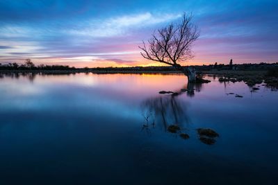 Scenic view of lake against romantic sky at sunset