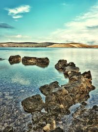 Scenic view of rocks in sea against sky