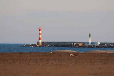 Lighthouse in sea against sky