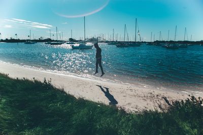 Scenic view of man jumping on beach