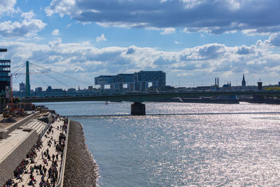 River against buildings and cloudy sky on sunny day