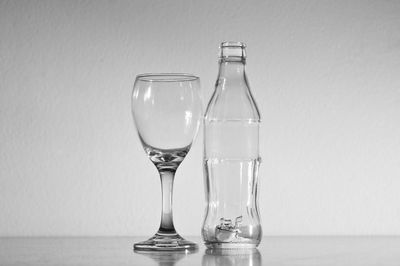 Glass of water on table against wall