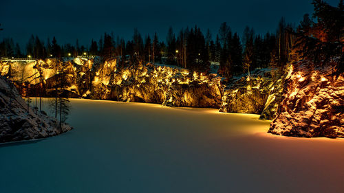 Scenic view of snow covered forest against sky at night