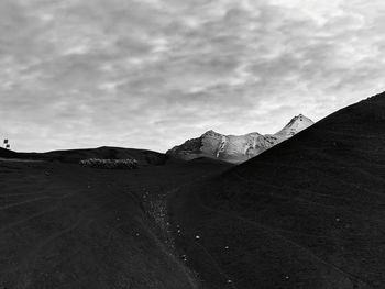 Scenic view of road by mountains against sky