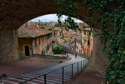 High angle view of woman walking on staircase amidst buildings