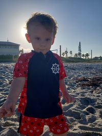 Portrait of boy standing against sky