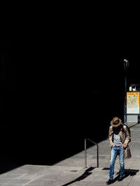 Young woman using phone while standing at night