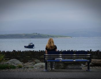 Rear view of man sitting on bench