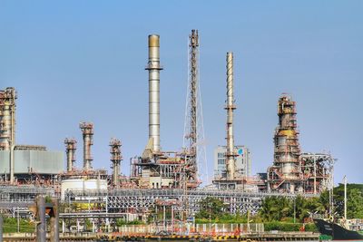 Low angle view of factory against clear blue sky