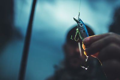 Close-up of man holding fishing bait