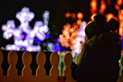 Rear view of silhouette woman standing against illuminated stage