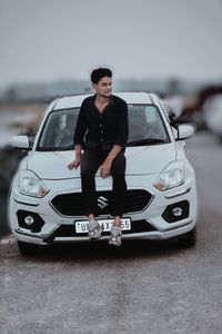 Portrait of young man standing in car