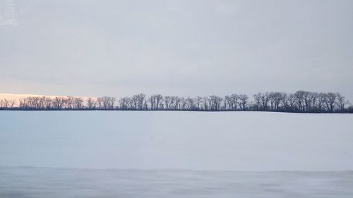 Scenic view of lake against sky during winter