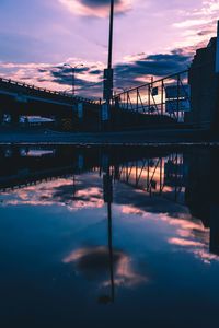 Reflection of bridge on water against sky