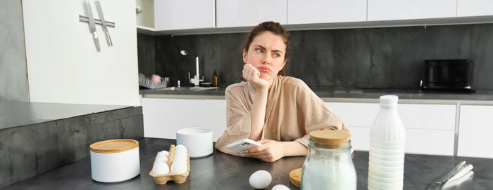 Young woman drinking coffee on table