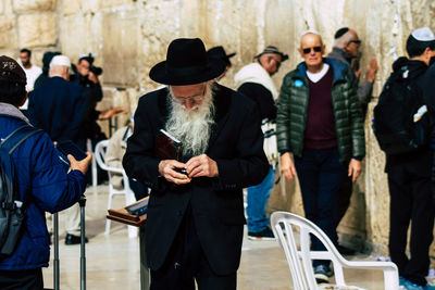 Group of people standing on mobile phone outdoors