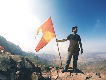Woman standing on mountain against sky