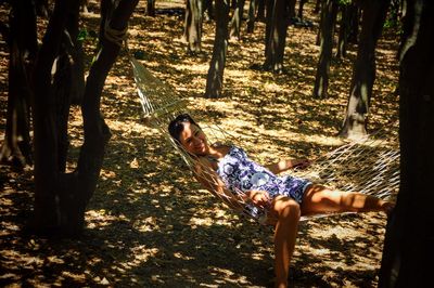 Portrait of woman relaxing in hammock at park