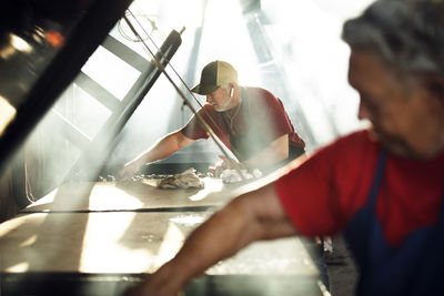 Workers cooking food in restaurant