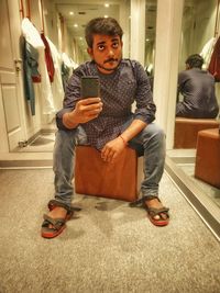 Full length portrait of man using mobile phone