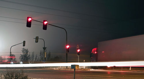 Traffic light on road at night