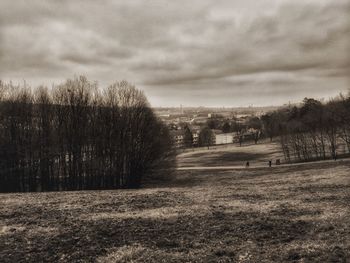 Scenic view of grassy field against cloudy sky