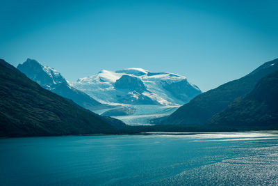 Scenic view of snowcapped mountains against blue sky