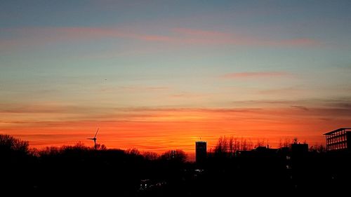 Silhouette of city against sky during sunset