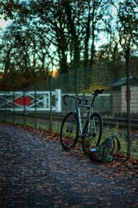 Bicycle parked by fence in city