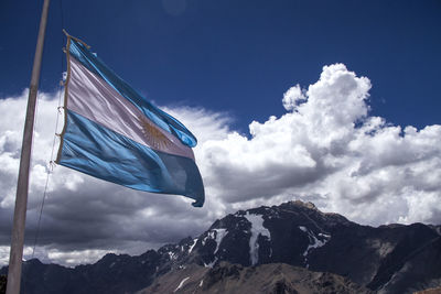 Low angle view of flag against mountain range