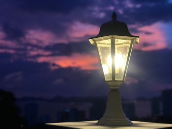 Close-up of illuminated light against sky at sunset