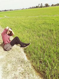 Young woman sitting on agricultural field